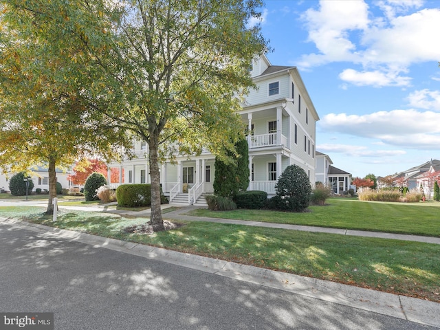 view of front of property featuring a front lawn and a balcony