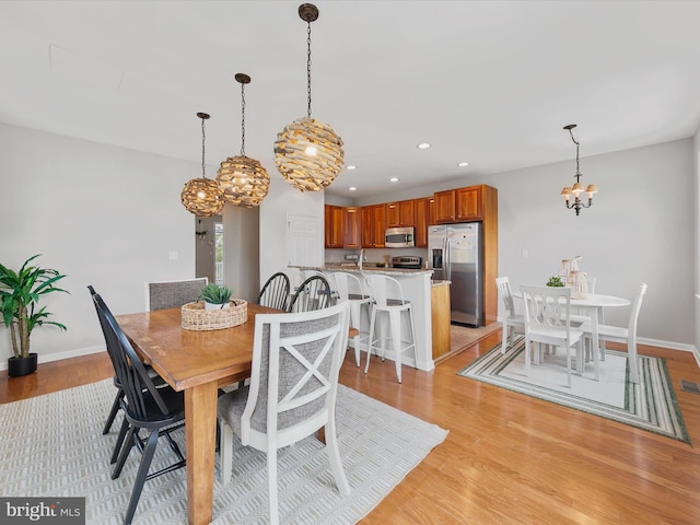 dining space featuring light hardwood / wood-style floors and a notable chandelier