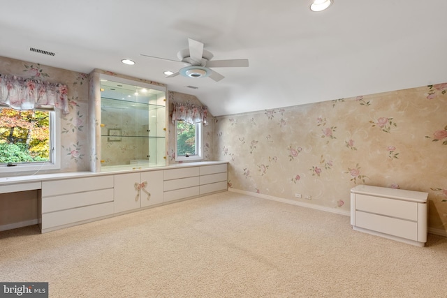 bathroom featuring a healthy amount of sunlight, vanity, ceiling fan, and lofted ceiling