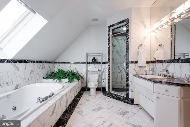 full bathroom featuring plus walk in shower, toilet, vaulted ceiling with skylight, vanity, and tile walls