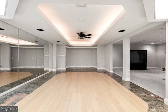 interior space with a tray ceiling and ceiling fan