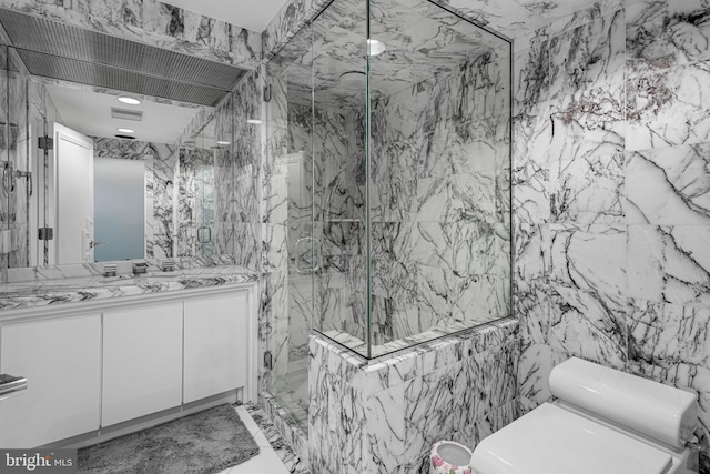 bathroom with vanity, a shower with shower door, tile walls, and toilet