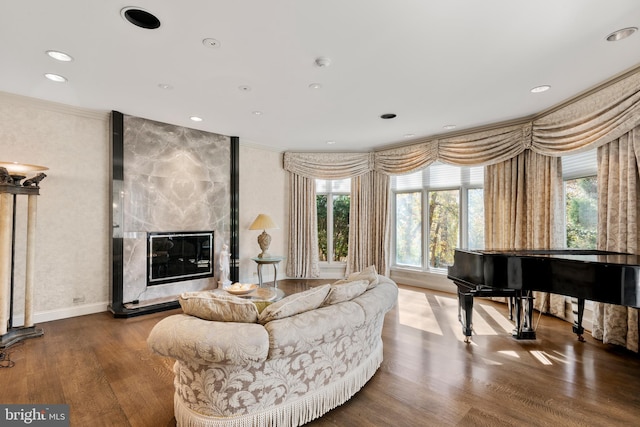 living room with hardwood / wood-style flooring, ornamental molding, and a fireplace