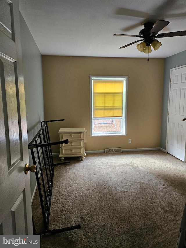 empty room featuring ceiling fan and carpet flooring