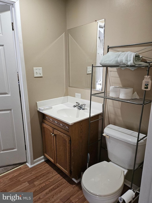 bathroom with vanity, hardwood / wood-style floors, and toilet