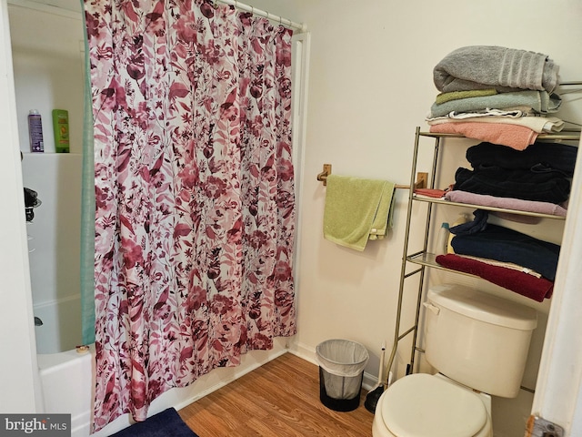 bathroom with shower / tub combo with curtain, toilet, and hardwood / wood-style floors