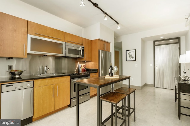 kitchen featuring sink, light tile patterned floors, and stainless steel appliances