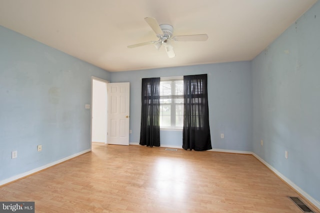 spare room with light wood-type flooring and ceiling fan