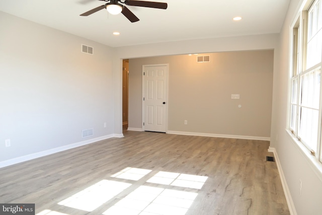 spare room with ceiling fan and light wood-type flooring