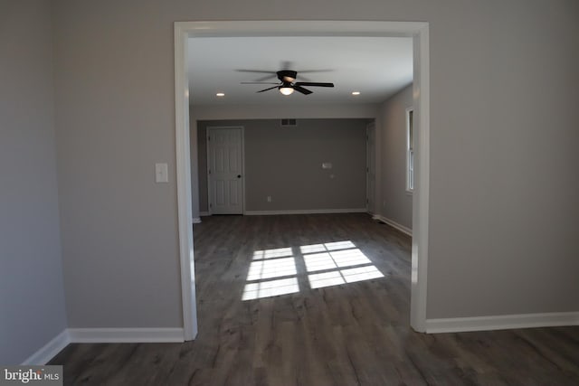 empty room with ceiling fan and dark hardwood / wood-style flooring