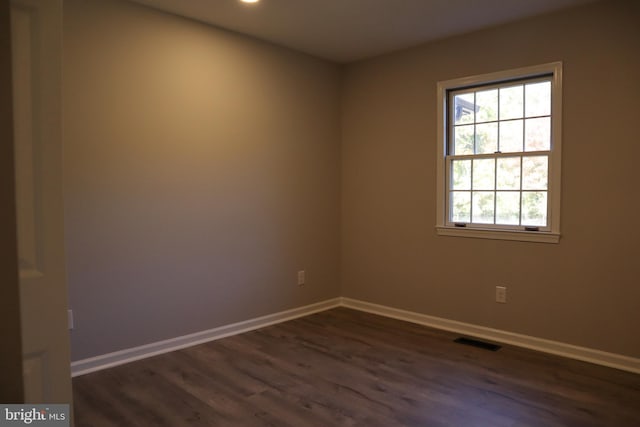 unfurnished room with dark hardwood / wood-style flooring