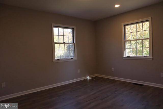 empty room with dark hardwood / wood-style flooring