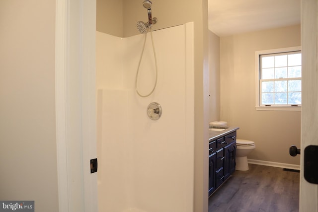 bathroom with toilet, walk in shower, wood-type flooring, and vanity