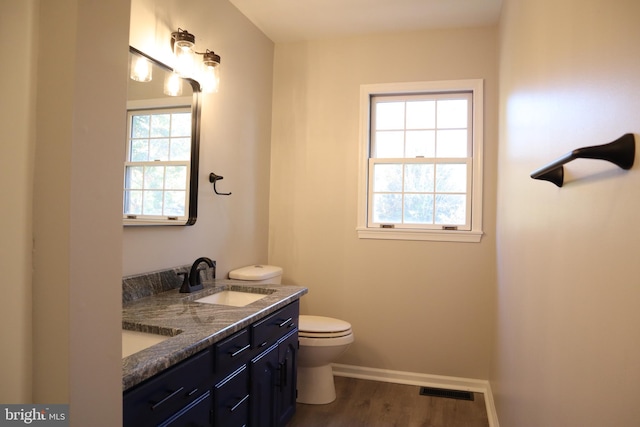 bathroom featuring toilet, vanity, and hardwood / wood-style floors