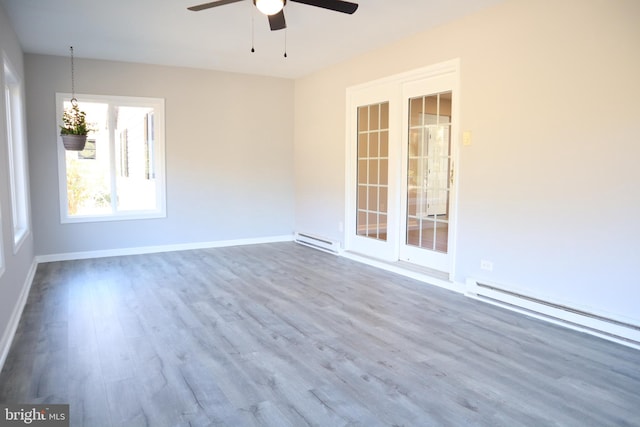 unfurnished room featuring hardwood / wood-style flooring, a baseboard heating unit, and ceiling fan