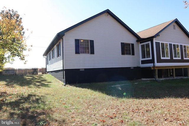 view of home's exterior featuring a sunroom and a lawn