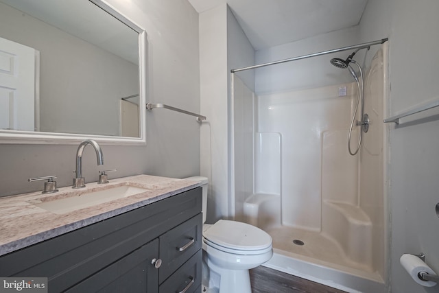 bathroom featuring vanity, toilet, a shower, and wood-type flooring