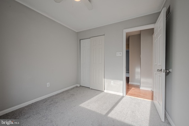 unfurnished bedroom with a closet, light colored carpet, and ceiling fan