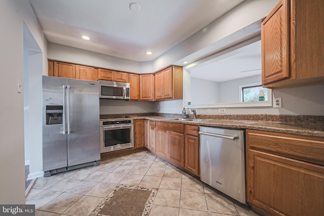 kitchen featuring stainless steel appliances, sink, and light tile patterned floors