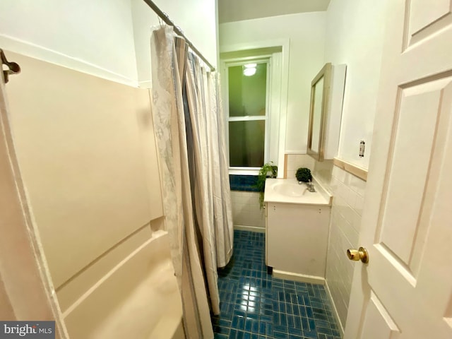 bathroom featuring tile patterned flooring, vanity, tile walls, and shower / tub combo