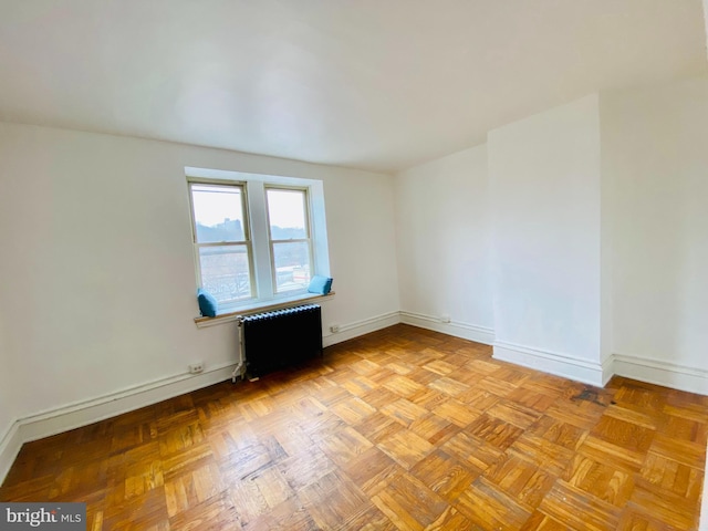 spare room with light parquet flooring and radiator