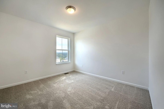 empty room featuring visible vents, baseboards, and carpet flooring