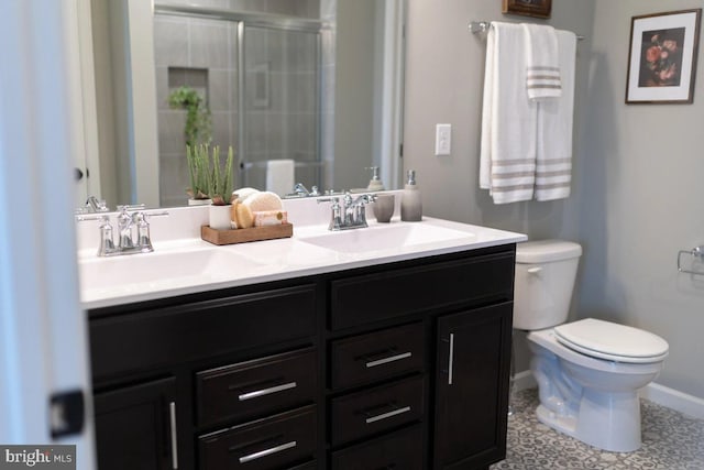 full bathroom with double vanity, a shower with shower door, toilet, and a sink