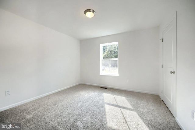 unfurnished room with visible vents, baseboards, and carpet flooring