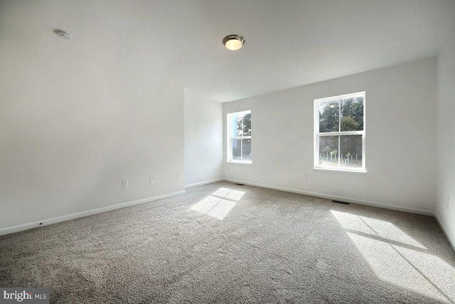 unfurnished room featuring carpet flooring, baseboards, and visible vents