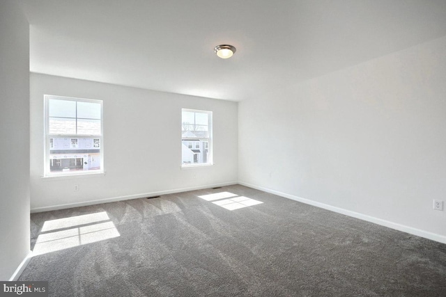 spare room featuring baseboards and carpet floors