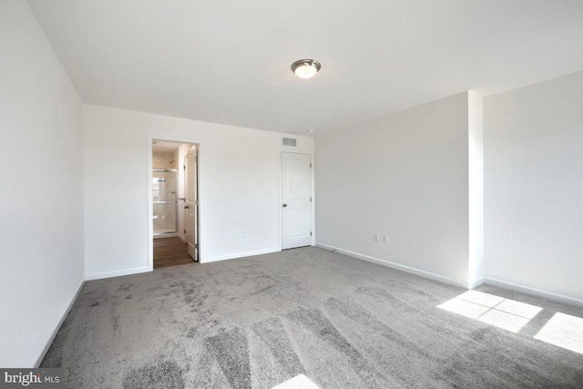 spare room featuring carpet flooring, baseboards, and visible vents