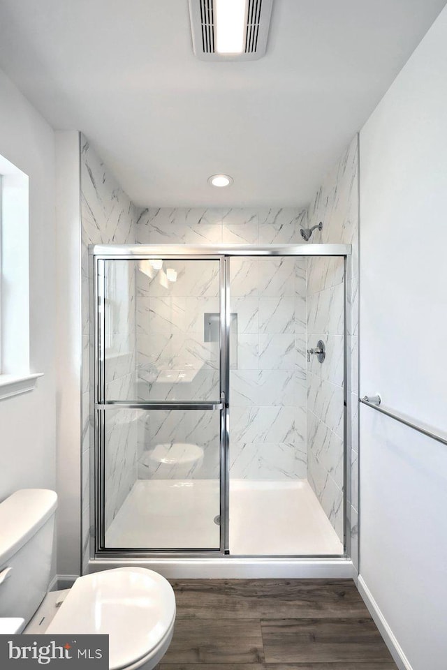 full bath featuring a marble finish shower, visible vents, toilet, recessed lighting, and wood finished floors