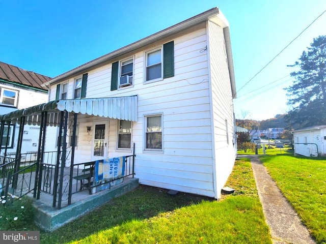 back of property featuring cooling unit and a lawn