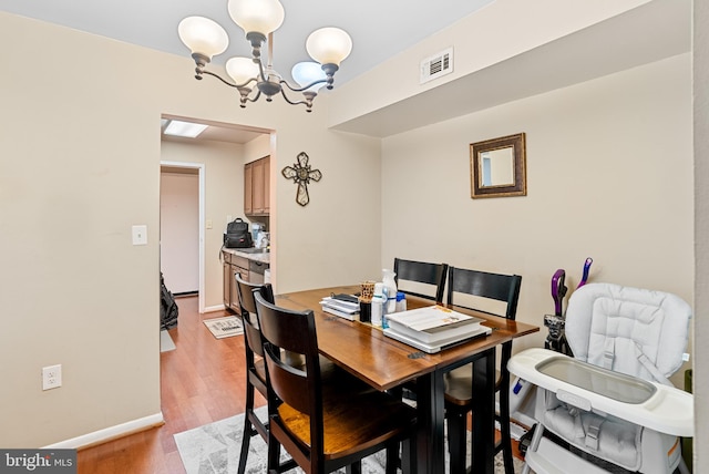 dining area featuring an inviting chandelier and light hardwood / wood-style flooring