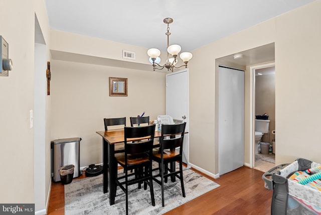 dining area with a chandelier and wood-type flooring