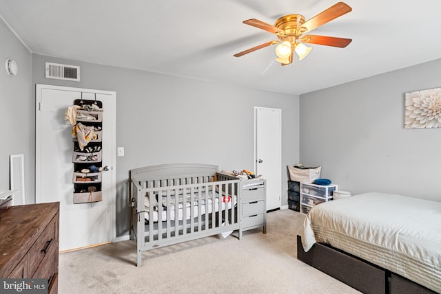 carpeted bedroom featuring ceiling fan and a closet