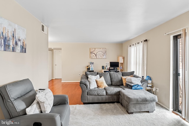 living room featuring light carpet and a wealth of natural light