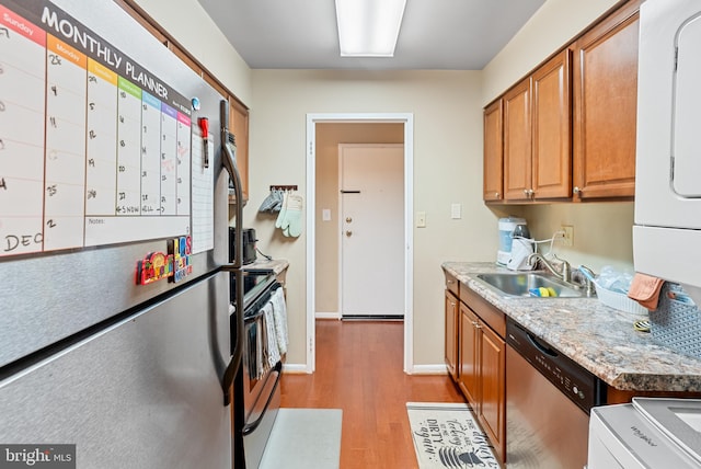 kitchen with stainless steel appliances, light hardwood / wood-style floors, and sink