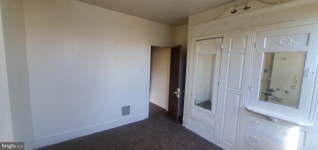 unfurnished bedroom featuring dark carpet