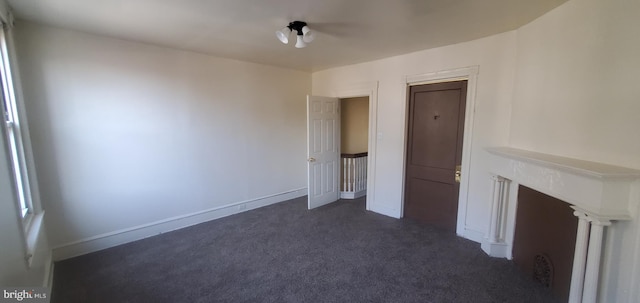 unfurnished living room featuring dark carpet