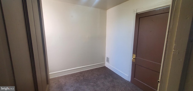 spare room with dark colored carpet