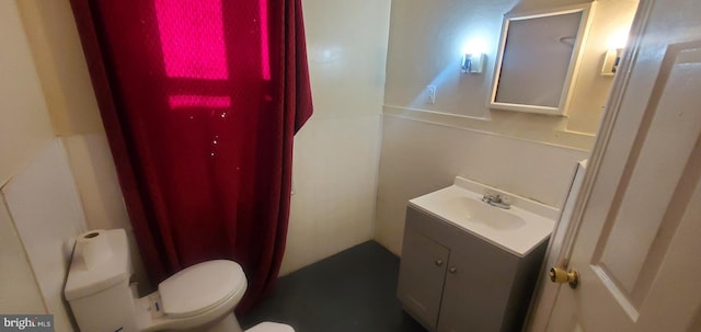 bathroom featuring vanity, curtained shower, and toilet