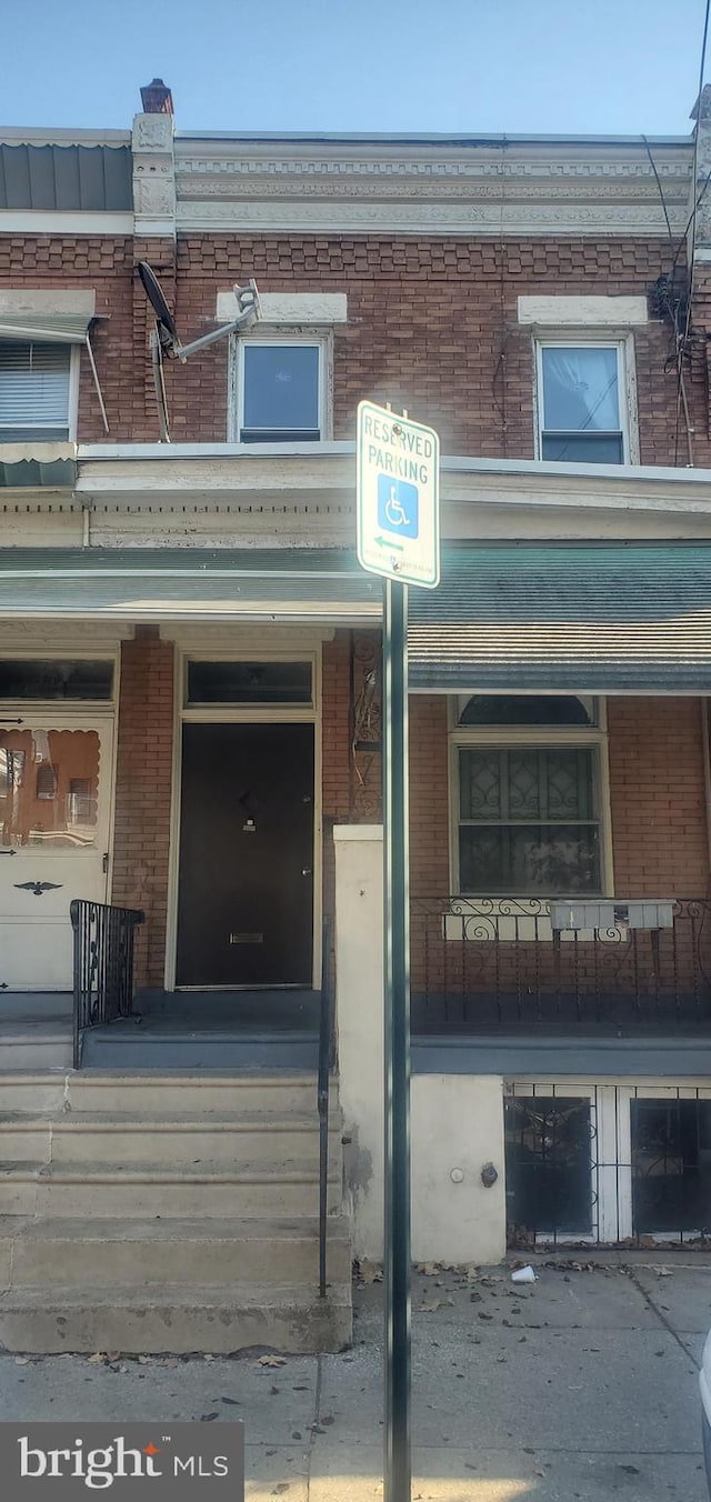 doorway to property with covered porch and a garage