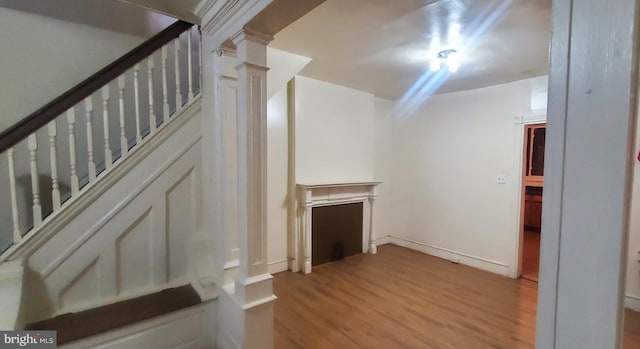 interior space with decorative columns and light hardwood / wood-style flooring