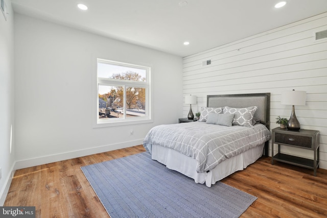 bedroom featuring wood walls and wood-type flooring