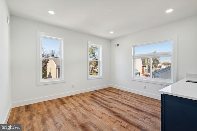 unfurnished dining area featuring a wealth of natural light and light hardwood / wood-style flooring