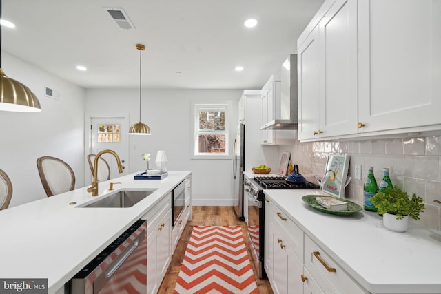 kitchen featuring light hardwood / wood-style floors, appliances with stainless steel finishes, a center island with sink, and sink