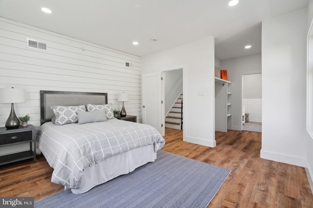 bedroom featuring wood walls and wood-type flooring