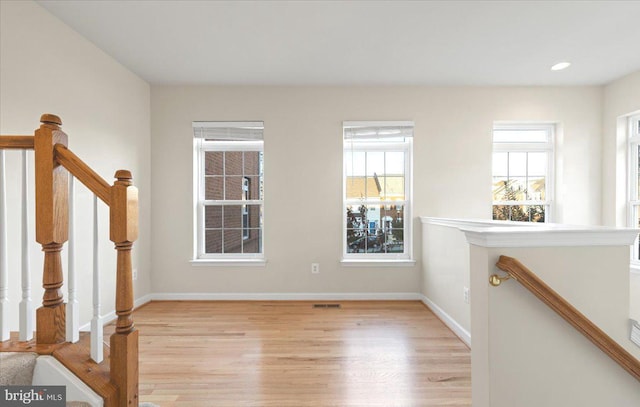 spare room featuring plenty of natural light and light hardwood / wood-style floors