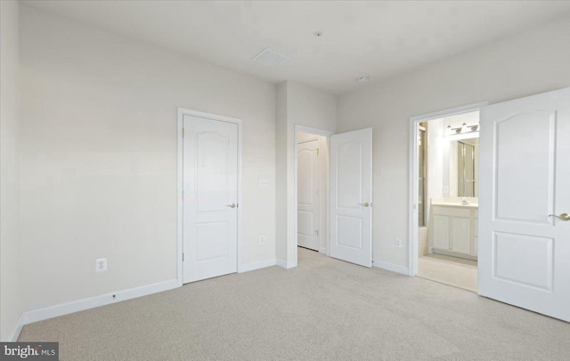 unfurnished bedroom with light carpet and ensuite bath